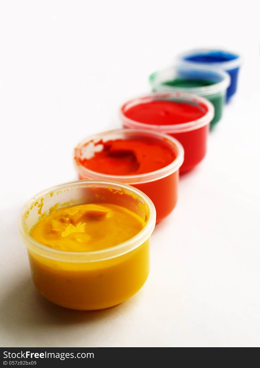 Open plastic containers of paint in primary colors. Open plastic containers of paint in primary colors