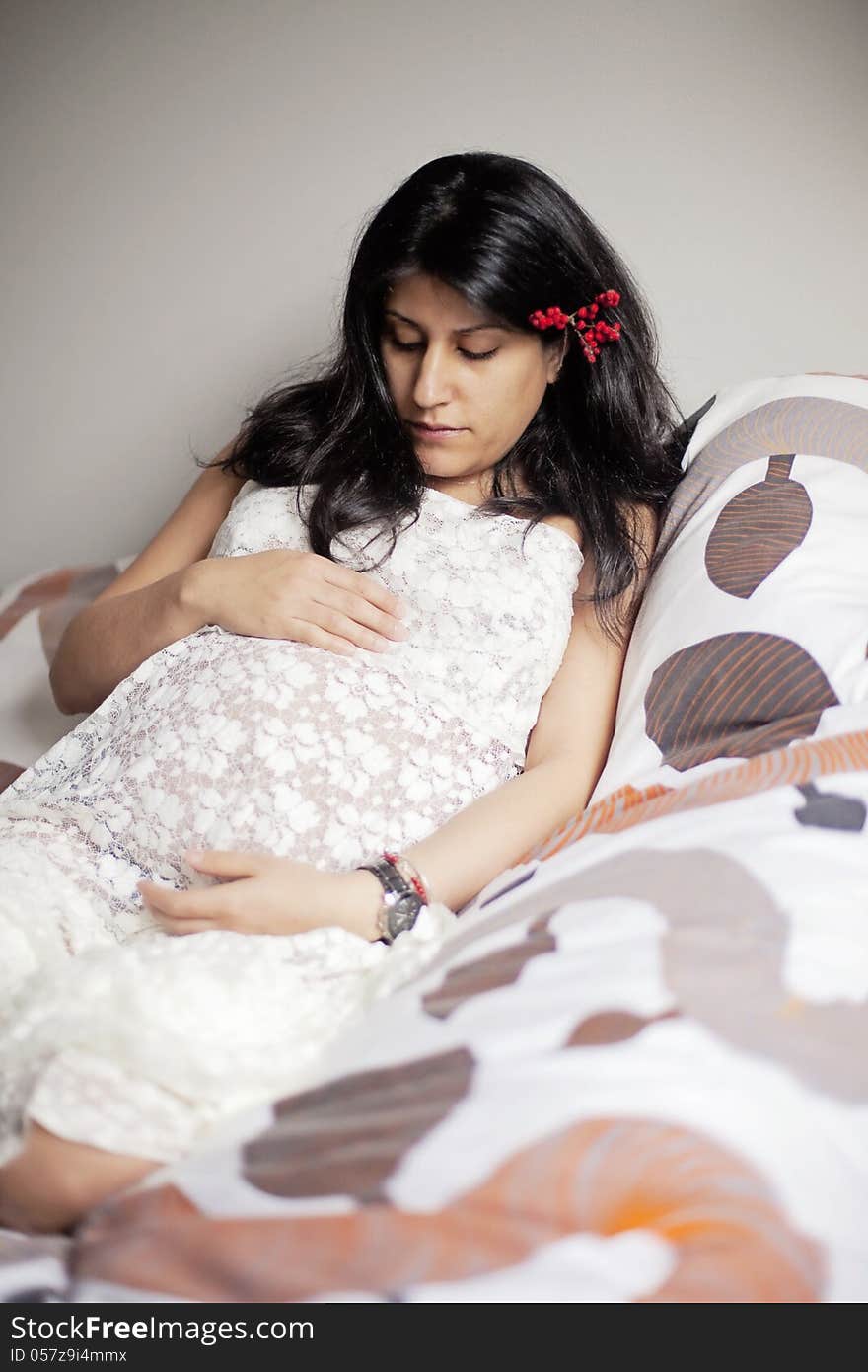 Portrait of pregnant young Iranian woman wearing lace sitting in bed. Portrait of pregnant young Iranian woman wearing lace sitting in bed.