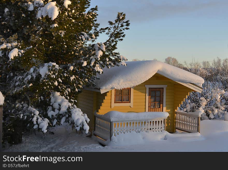 Snow-covered cottage covered with powder snow