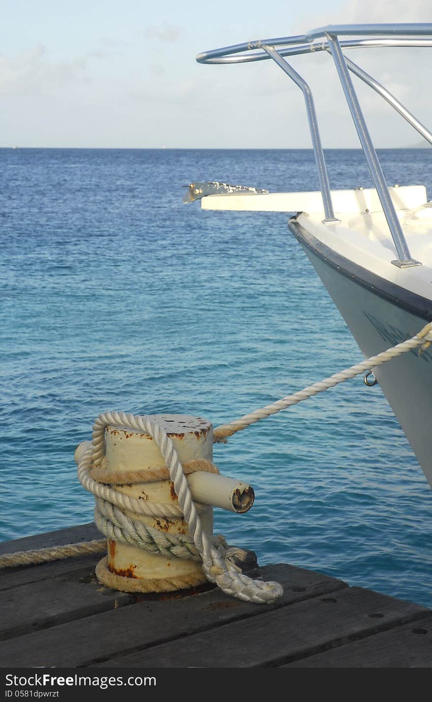 The bow of a boat moored to a bollard.