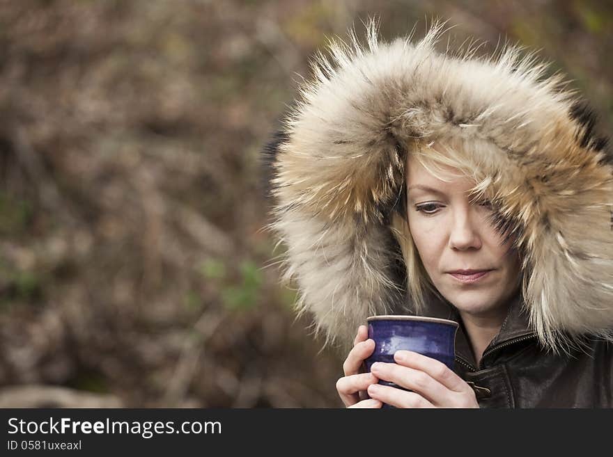 Portrait of a blonde woman in attractive winter coat drinking coffee. Portrait of a blonde woman in attractive winter coat drinking coffee.