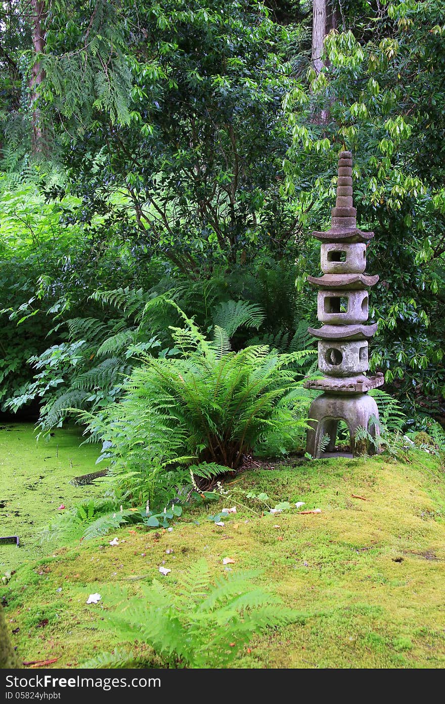 Japanese garden with a stone temple statue.