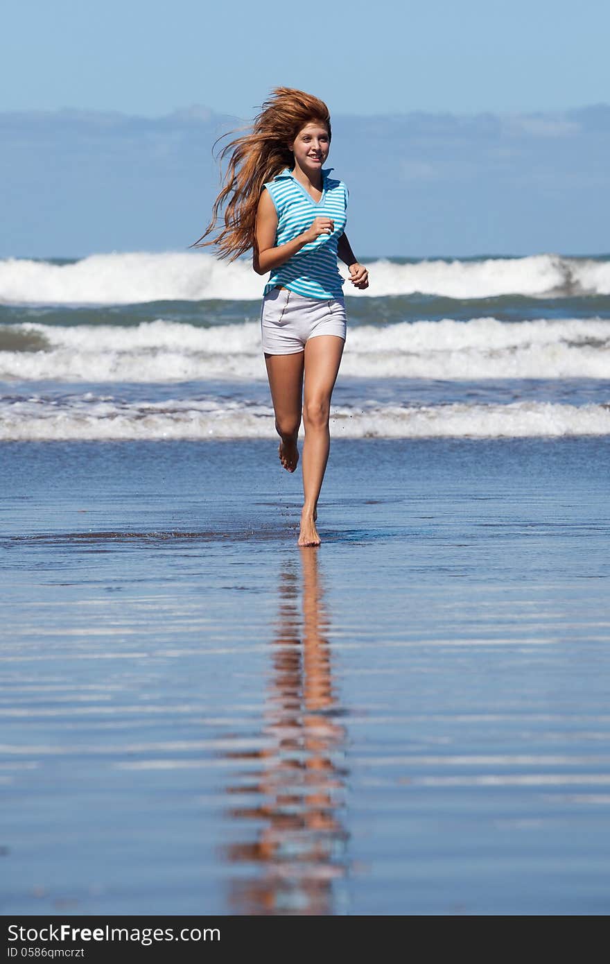 Happy young woman running at the beach. Happy young woman running at the beach