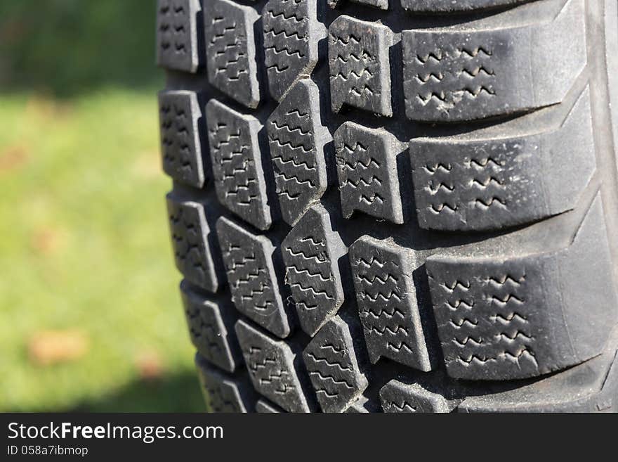 Old car tire on green background. Old car tire on green background.