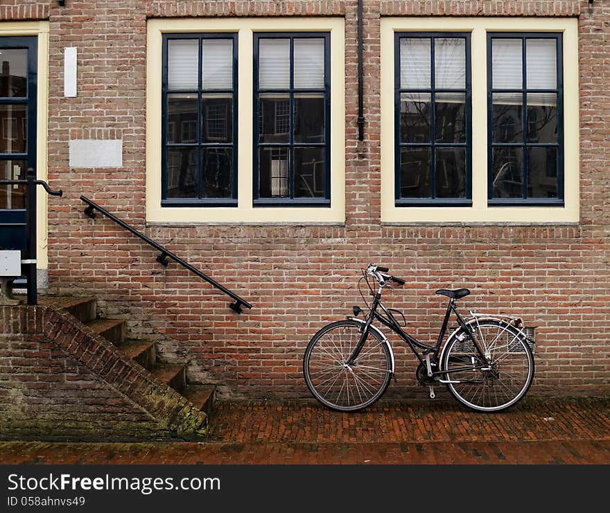 A classic bicycle against brick wall at streets of Middelburg, Netherlands. A classic bicycle against brick wall at streets of Middelburg, Netherlands.