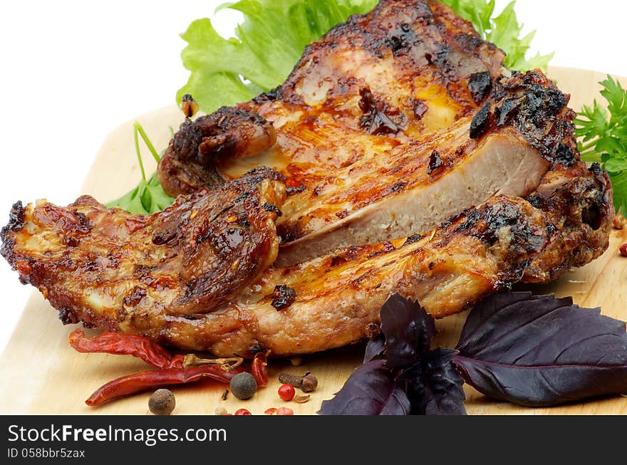 Barbecue Pork Ribs with Lettuce, Basil and Spices closeup on Cutting Board