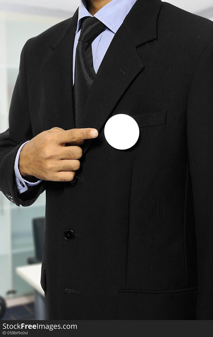 Man with black business suit with blank pinned button. You can put your design on the button. Election day background or concept. Man with black business suit with blank pinned button. You can put your design on the button. Election day background or concept