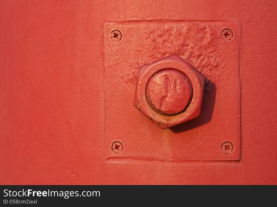 Nut and bolt fixed on red post with screws