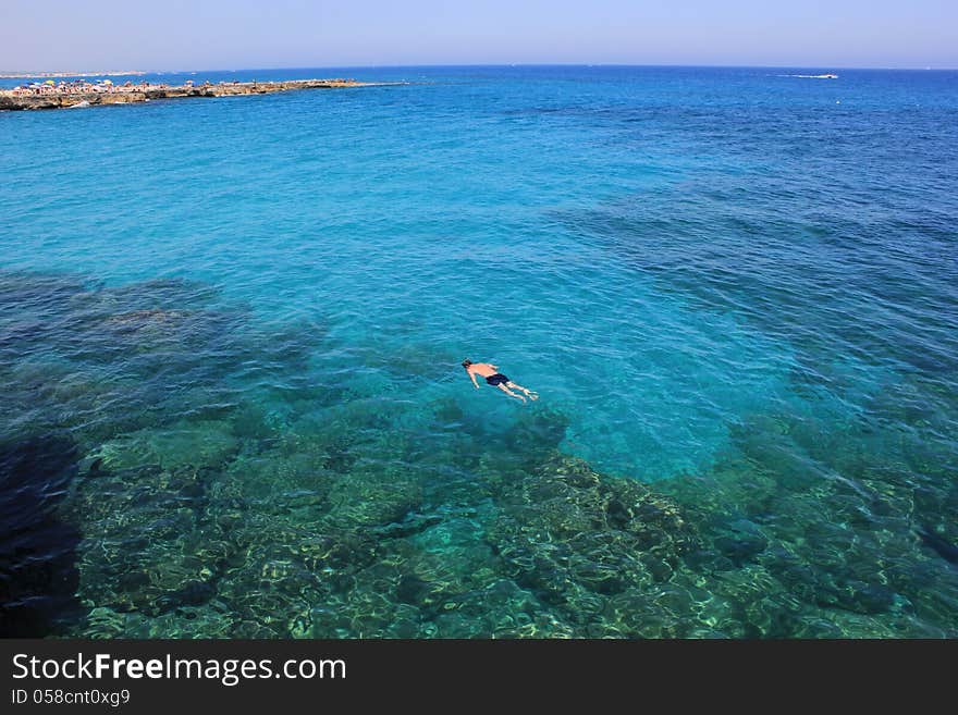 A holiday immersed in the blue sea of Sardinia. A man do snorkeling in quiet sea. A holiday immersed in the blue sea of Sardinia. A man do snorkeling in quiet sea.