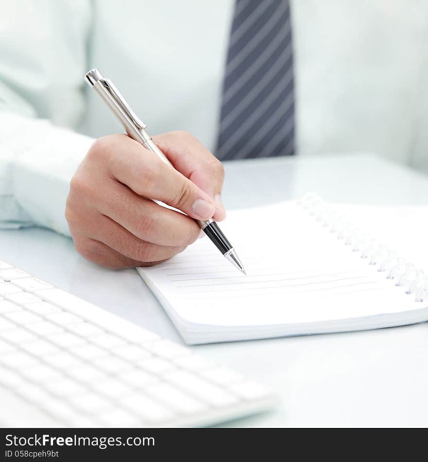 Businessman signing a document on the desk