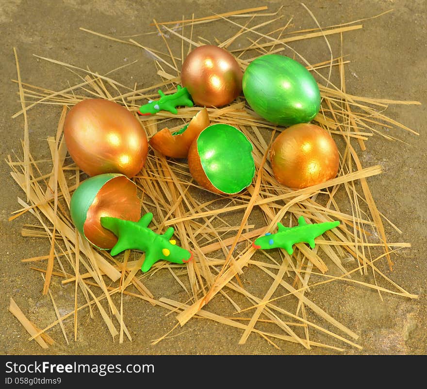 Gold and green eggshells with tiny crocodiles made of clay. Gold and green eggshells with tiny crocodiles made of clay