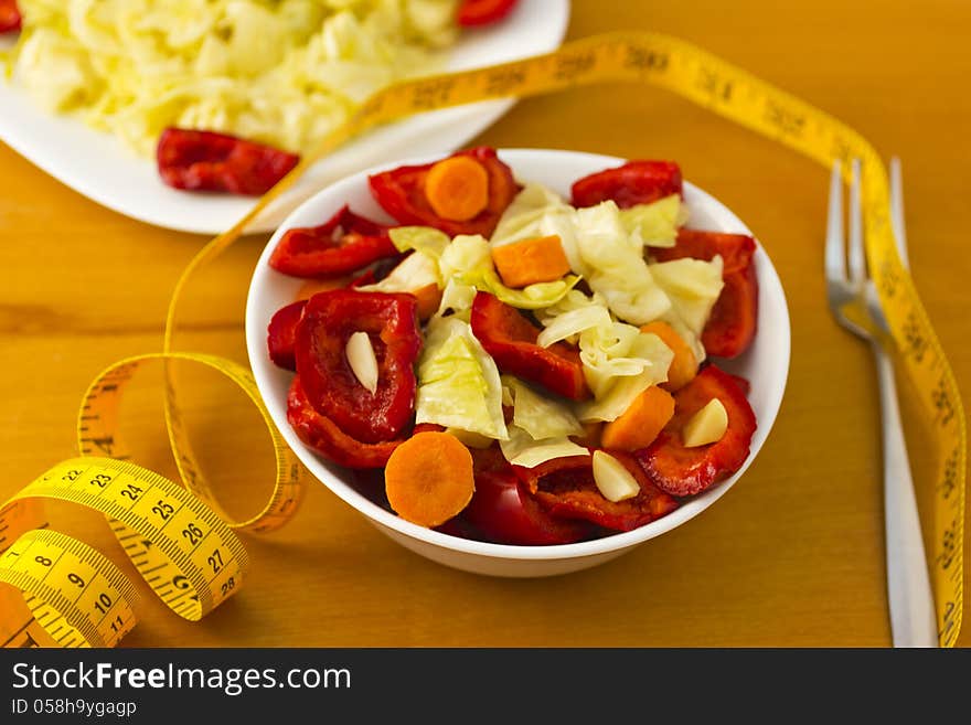 Bowl and plate with vegetables on table. Bowl and plate with vegetables on table.