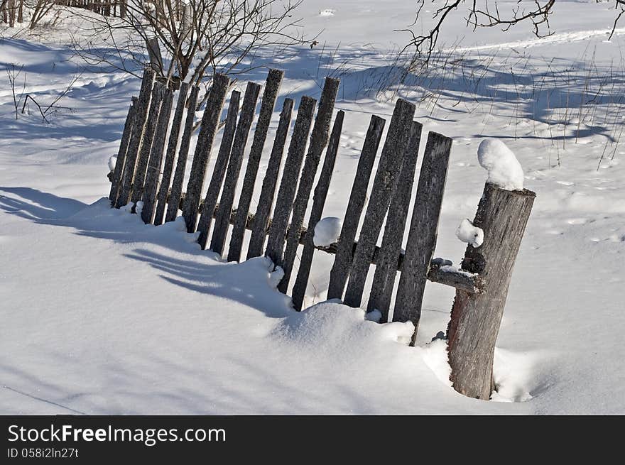 Fragment of old broken wooden fence on the village outskirts