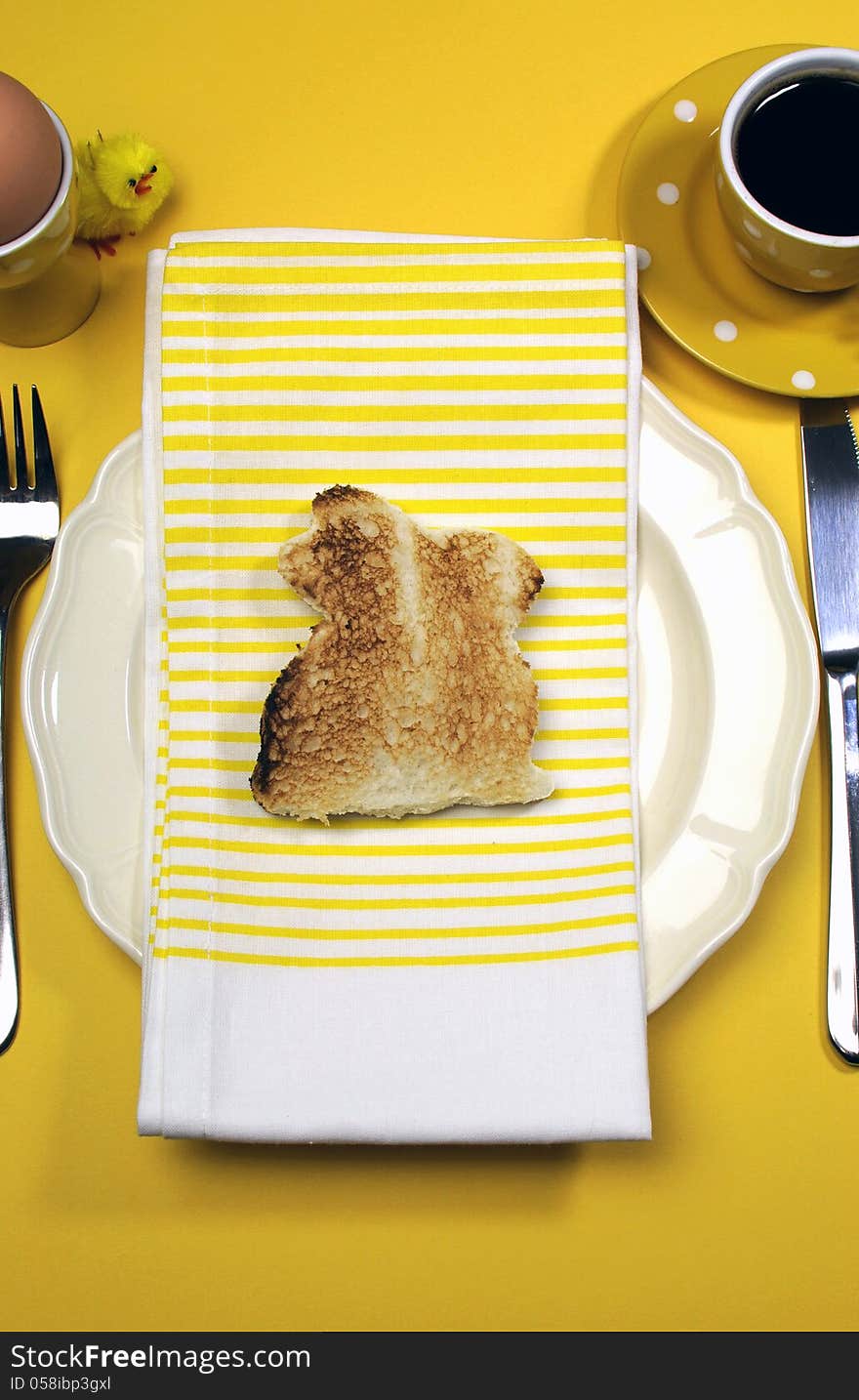 Yellow theme Happy Easter breakfast table with bunny rabbit toast - vertical