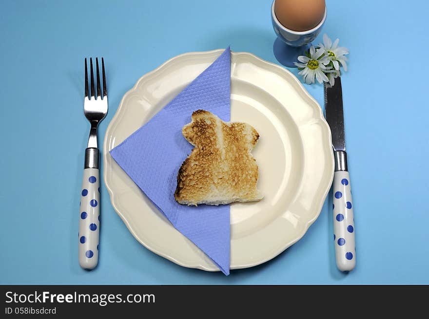 Blue theme Happy Easter breakfast table with bunny rabbit toast and egg.