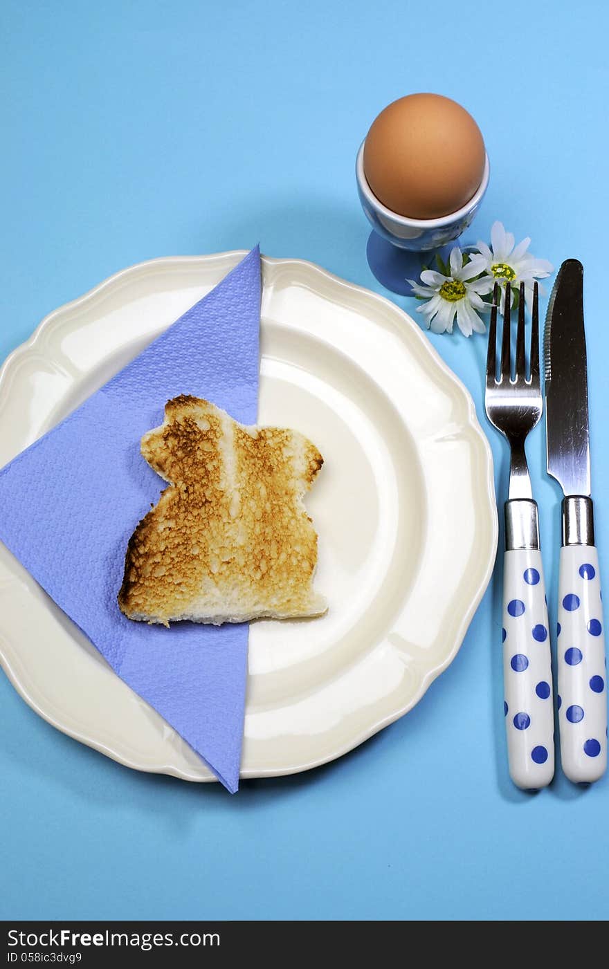 Blue theme Happy Easter breakfast table with bunny rabbit toast and egg. Vertical.