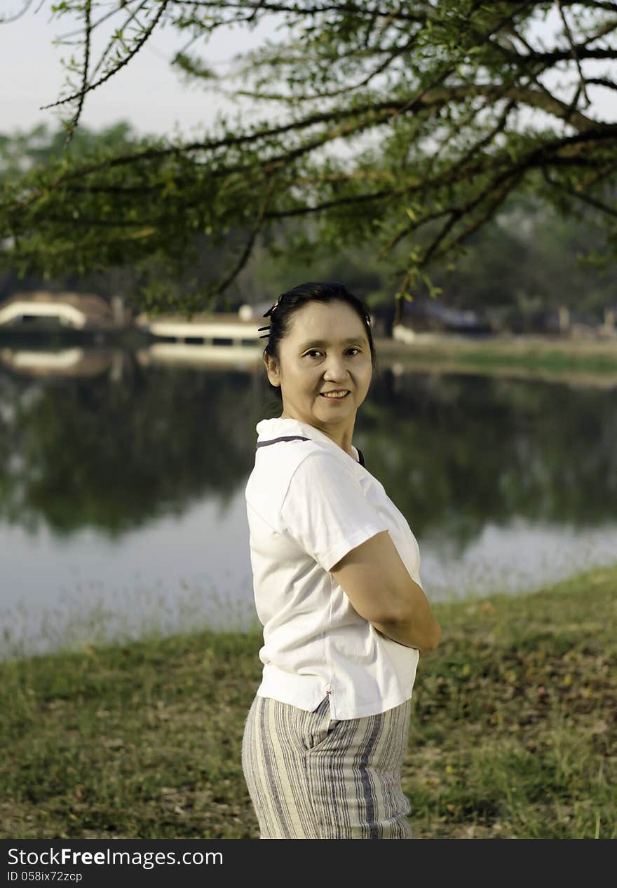 Happy asian woman posing against a background of nature