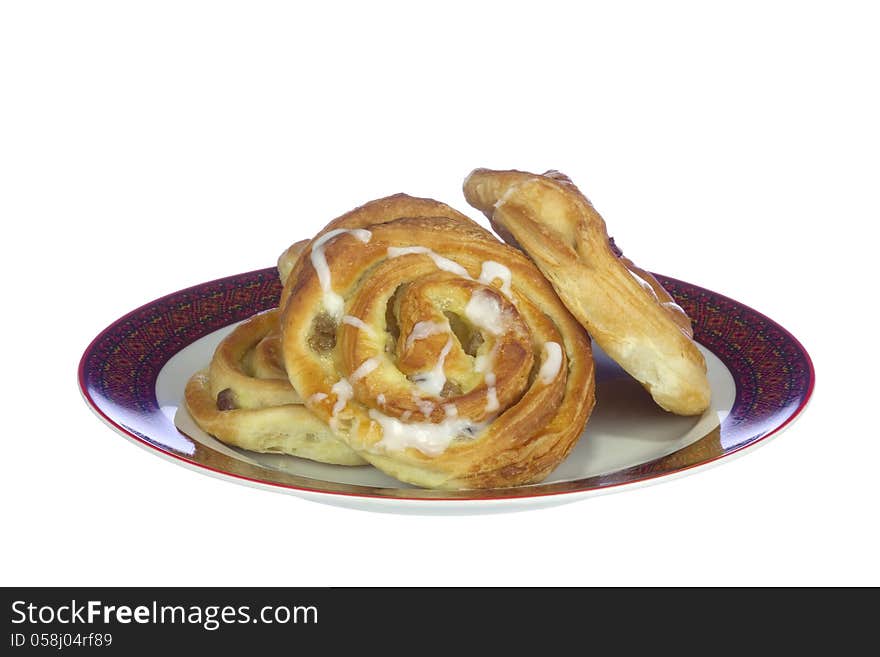 Buns with cream and raisins on the plate, isolated on white background