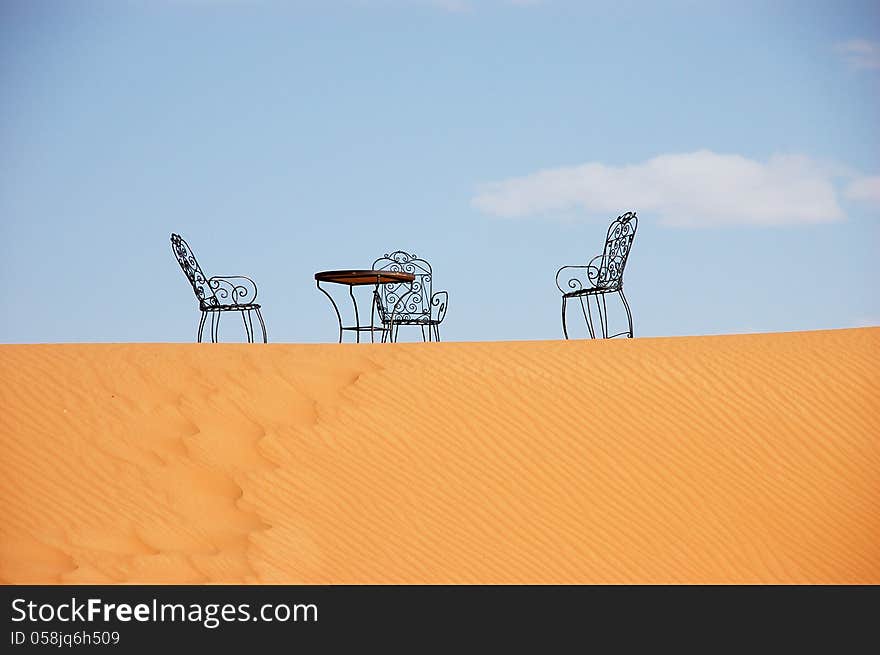 Wrought Iron Table And Chairs On The Top Of Sand Dune