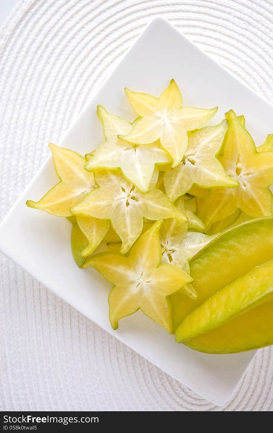 Sliced fresh starfruit serve on white plate. Sliced fresh starfruit serve on white plate