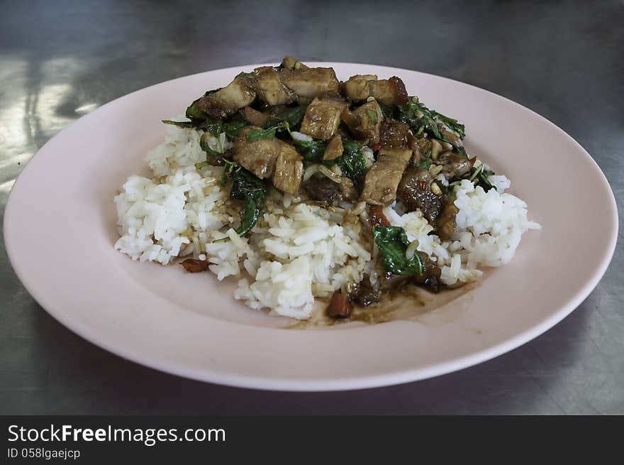 Rice with stir fried hot and spicy pork with basil .