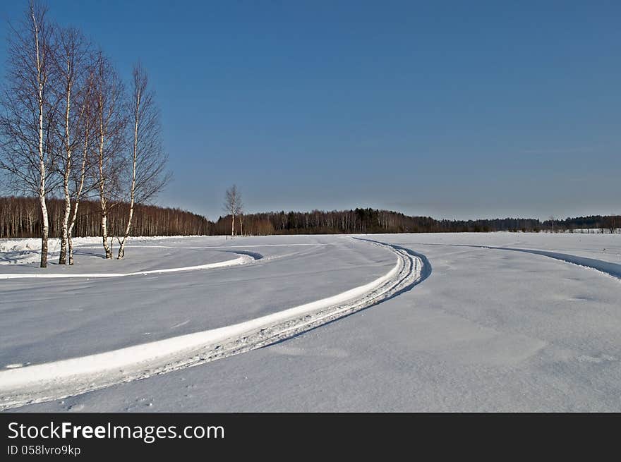 Snowmobile tracks in winter field