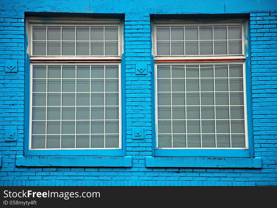 Two windows in old blue brick wall. Two windows in old blue brick wall