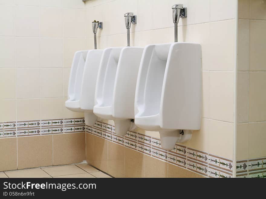Ceramic urinals in public toilet. Ceramic urinals in public toilet