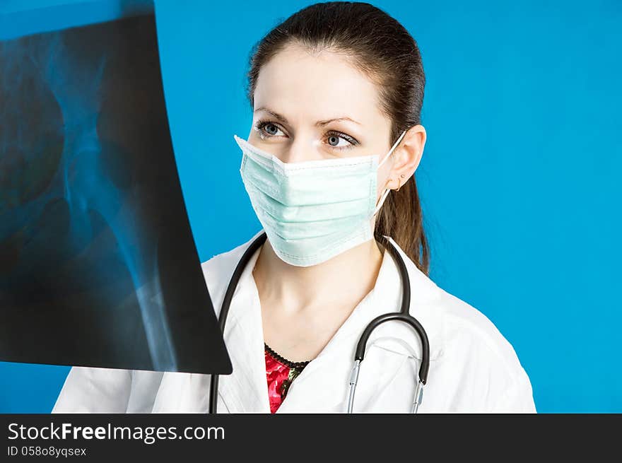 Young doctor in a mask holds X-ray