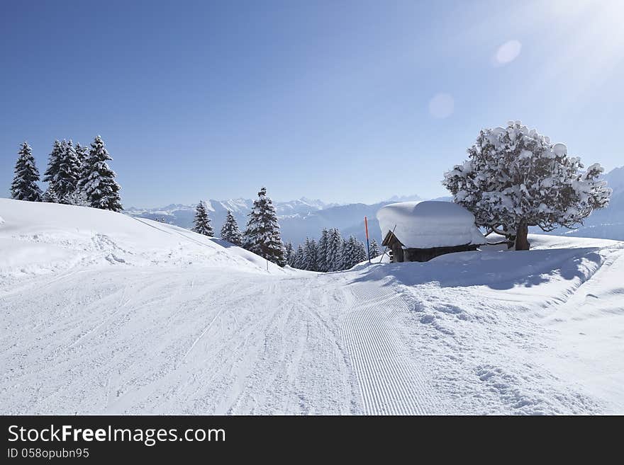 Beautiful brightly lit scenic view of mountain slope with a hut.