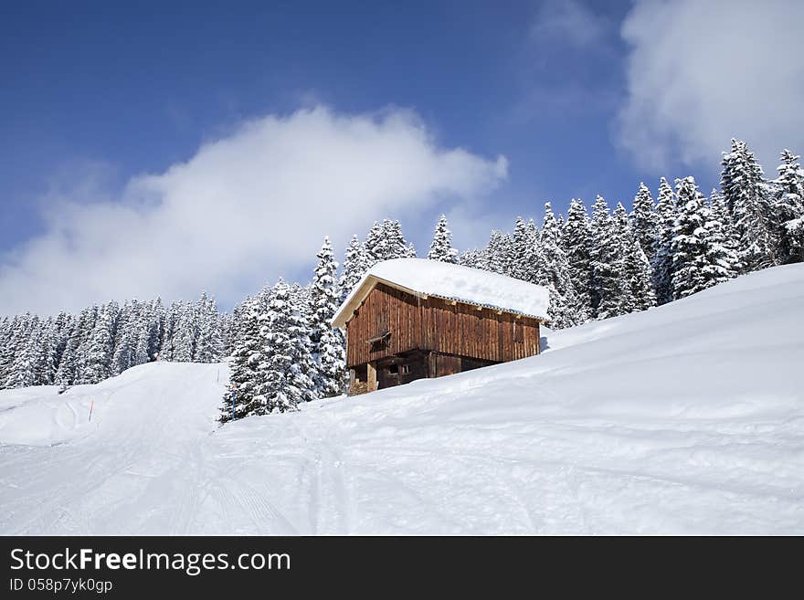 Beautiful brightly lit scenic view of mountain slope with a hut.