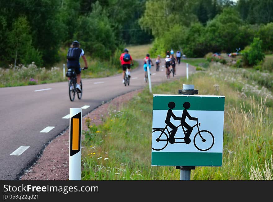 Cyclists on the road and traffic sign