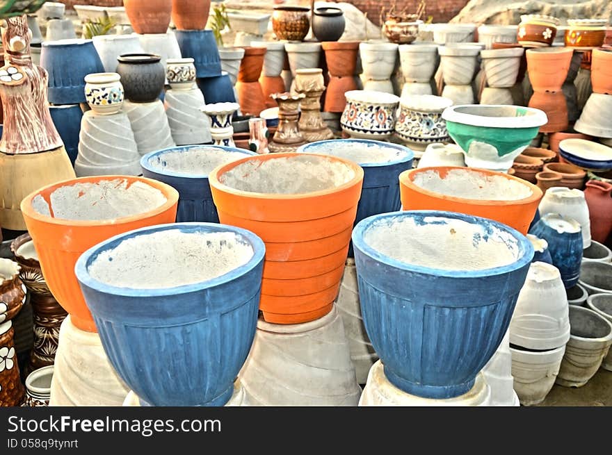 Many different colorful flower pots in workshop. Many different colorful flower pots in workshop.