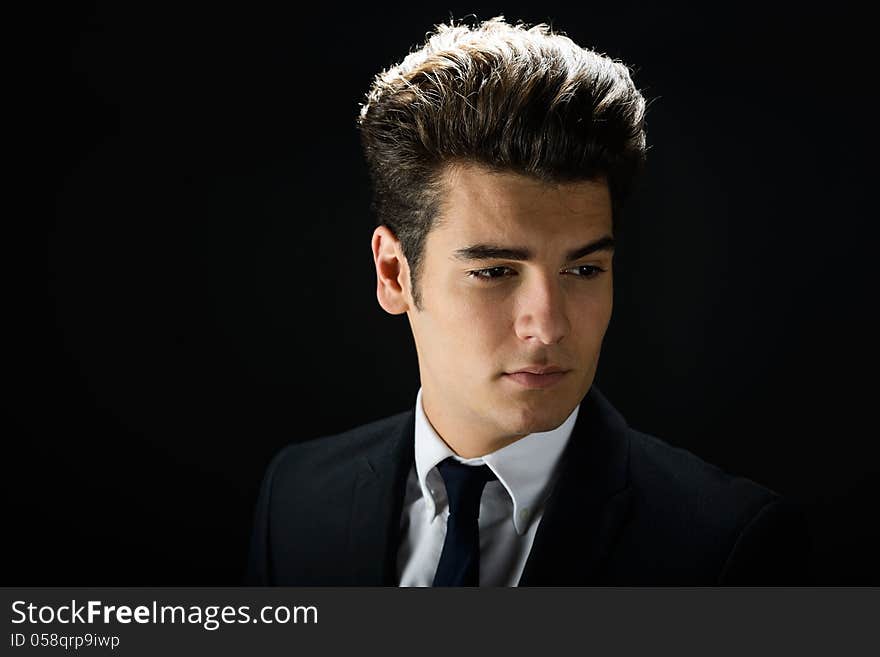 Young businessman, on black background