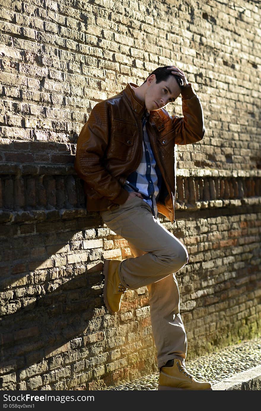 Portrait of handsome man with modern hairstyle smiling in urban background