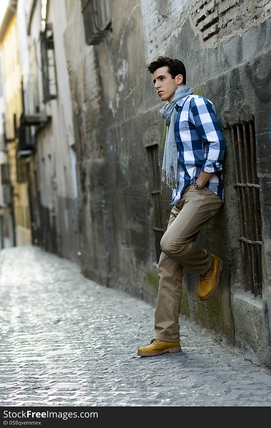 Portrait of handsome man with modern hairstyle in urban background