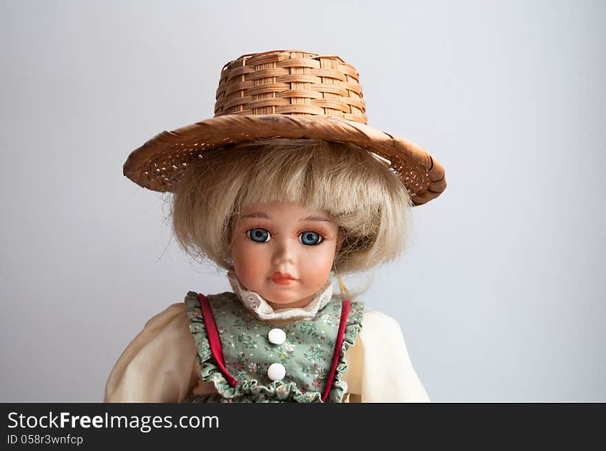 Photo the doll on a light background . Pretty doll in the antique dress