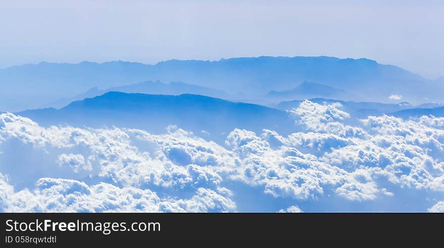 Clouds and mountains from a height, the view from the airplane window. Clouds and mountains from a height, the view from the airplane window