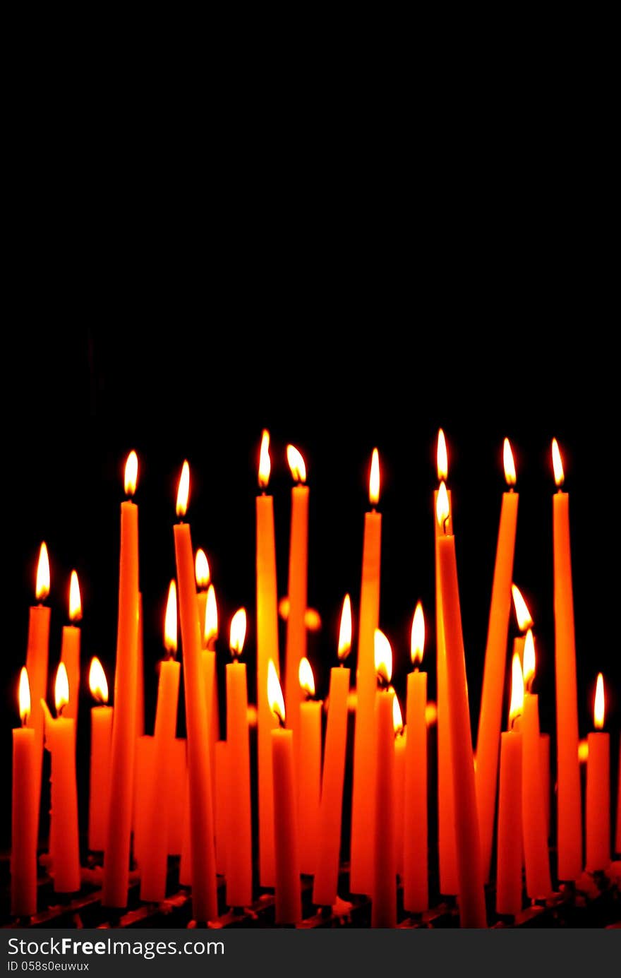 Group of burning candles on black background