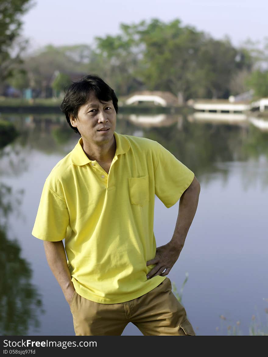 A portrait of a senior south asian man by lake. A portrait of a senior south asian man by lake