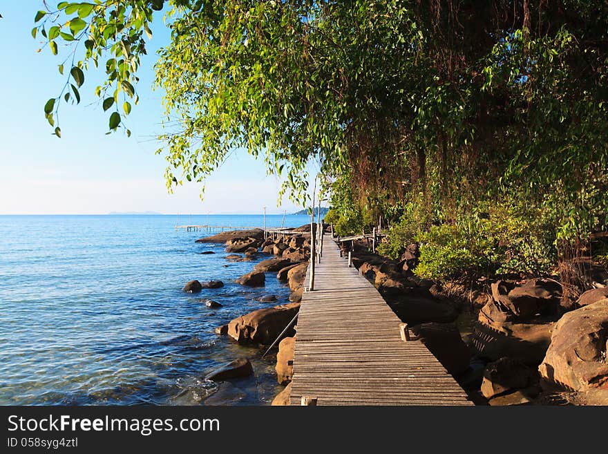 Wooden bridge among the rocks along the seashore. Beautiful sea landscape.