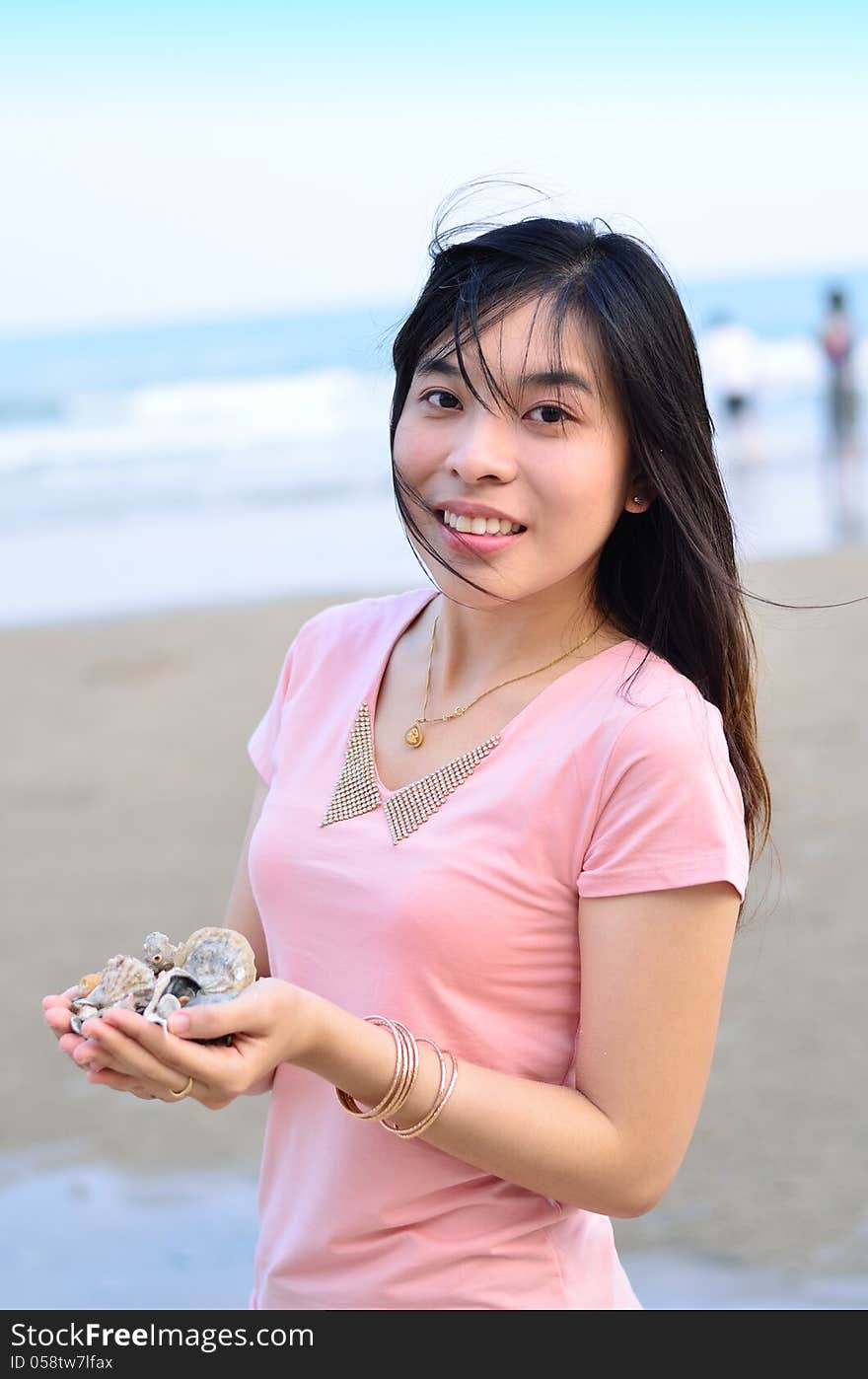 Beautiful asian woman holding shell on hand