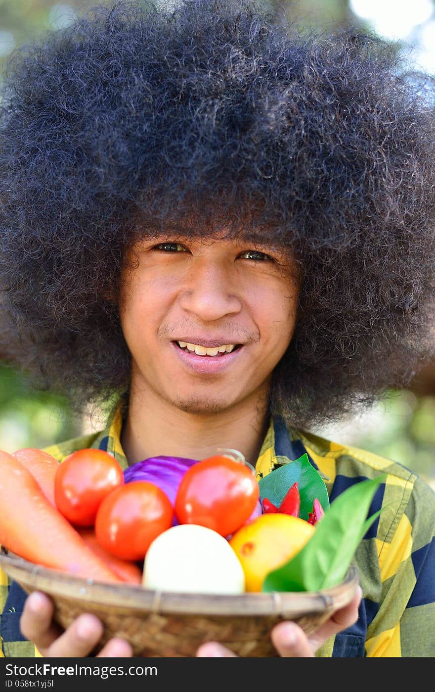 Close up Man holing bucket of colourful vegetables