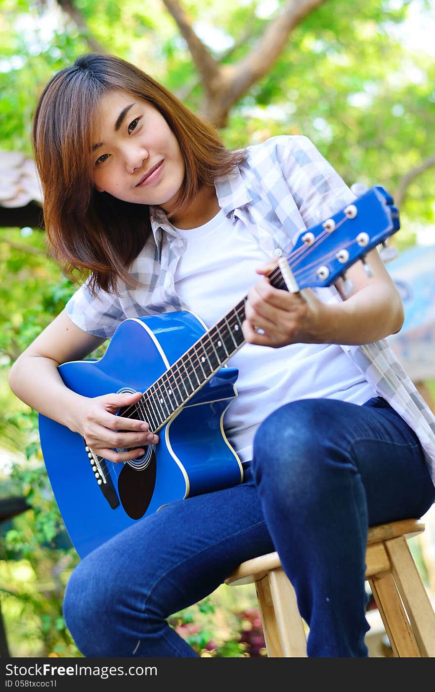 Beautiful asian woman holding Guitar