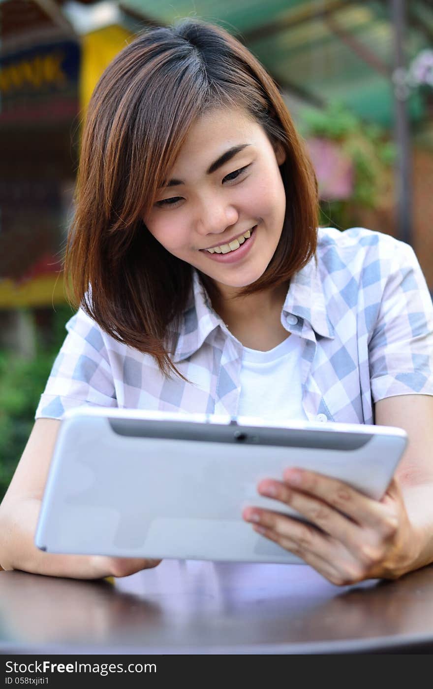 Beautiful young student have good news on the tablet screen