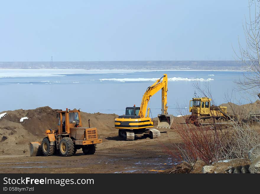 Excavation tractors on the river in the spring. Excavation tractors on the river in the spring