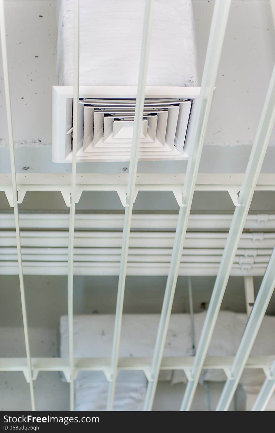 Air conditioner over white colored steel grid. Air conditioner over white colored steel grid