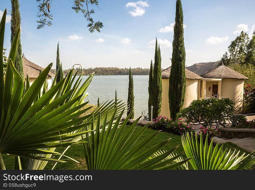 Cottages in a beautiful setting with palm leaves, well maintained garden and a lake in the background. Cottages in a beautiful setting with palm leaves, well maintained garden and a lake in the background