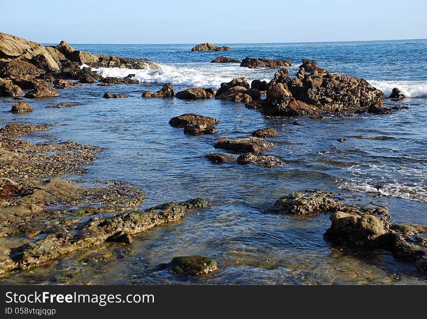 Shows a rugged, rocky shoreline inter-tidal zone with tide pools along the coastline north of the Main Beach of Laguna Beach. The coastline in this area is now a protected preserve which prevents damage to the marine life. Visitors can still look but no fishing or removal of marine organisms from tide pools is allowed. Shows a rugged, rocky shoreline inter-tidal zone with tide pools along the coastline north of the Main Beach of Laguna Beach. The coastline in this area is now a protected preserve which prevents damage to the marine life. Visitors can still look but no fishing or removal of marine organisms from tide pools is allowed.