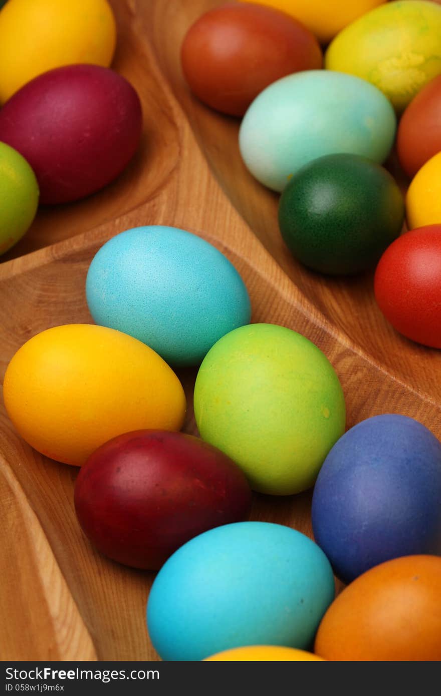 Colorful easter eggs in wooden tablemat.